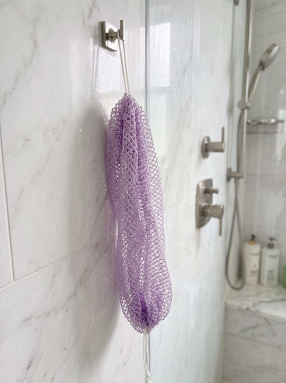 Lavender African net sponge hanging in a shower